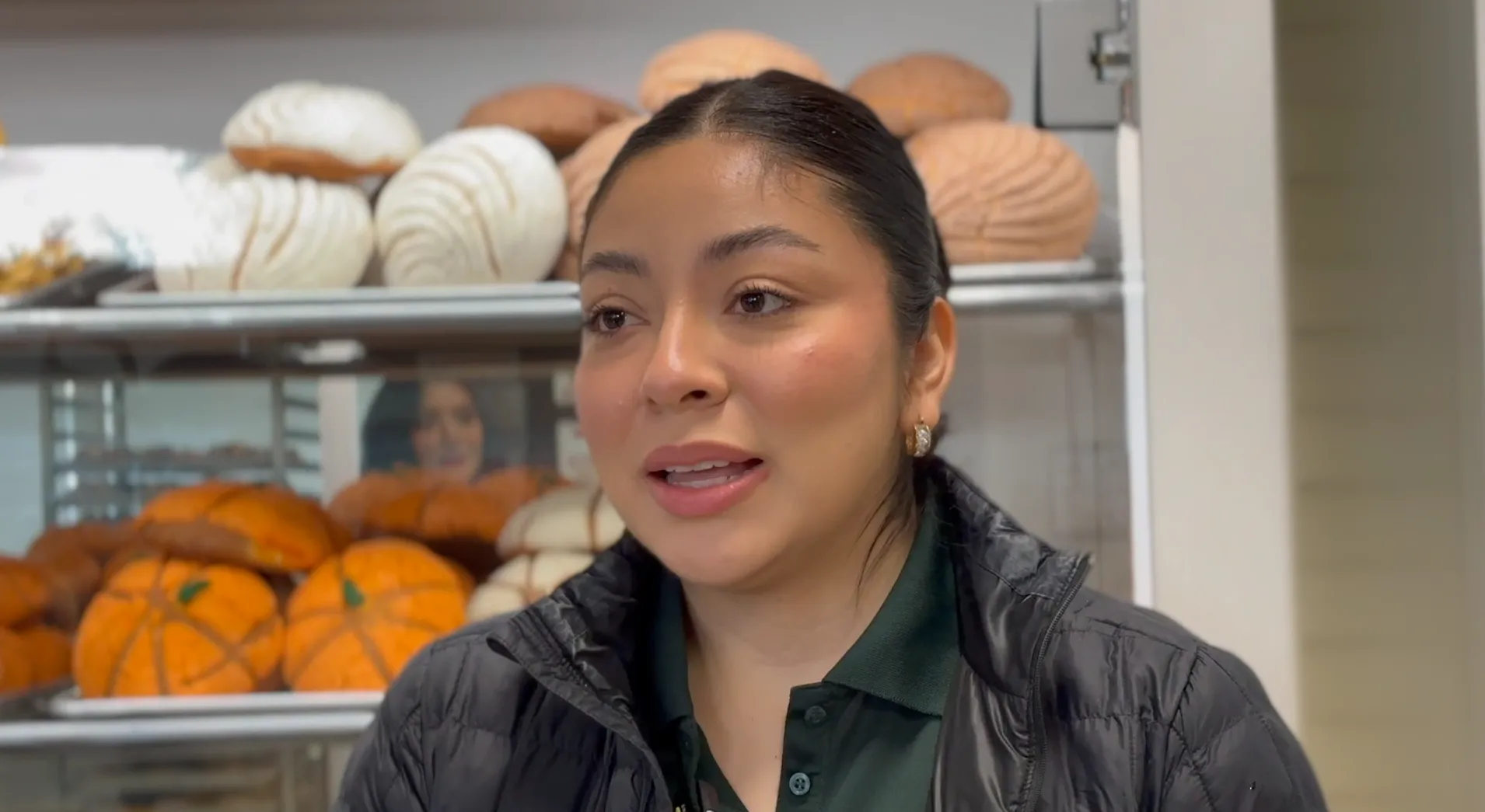 An interview inside La Esperanza with shelves of fresh bread in the background